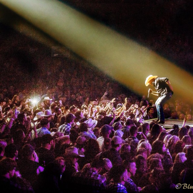 Spotlight on Justin Moore singing while fans wave