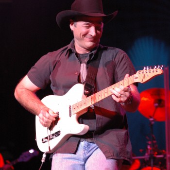 Clint Black playing the guitar on stage.