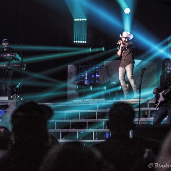 View of Justin Moore singing on stage from the crowd.