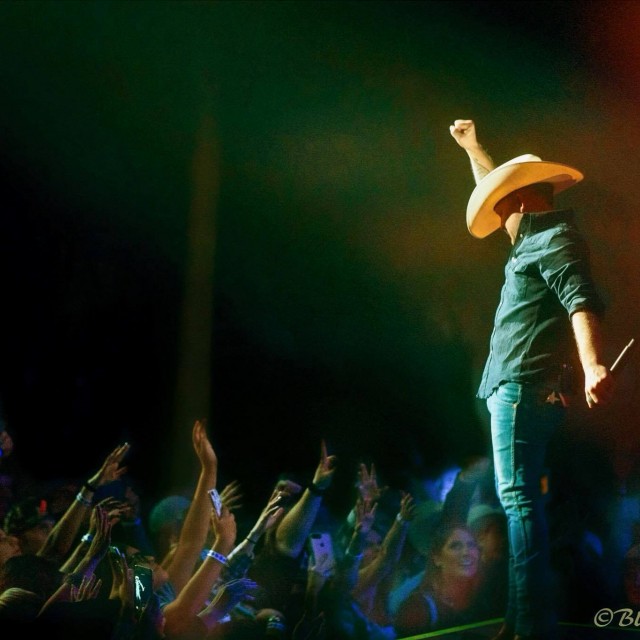 Justin Moore fist raised while fans wave