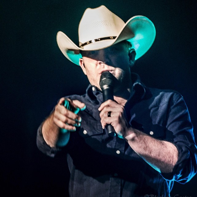 Close up of Justin Moore singing and pointing into camera lens