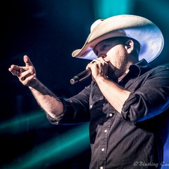 Close up shot of Justin Moore singing on stage.