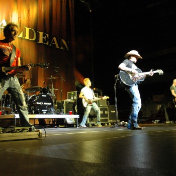Front row shot of a country band playing guitars on stage.